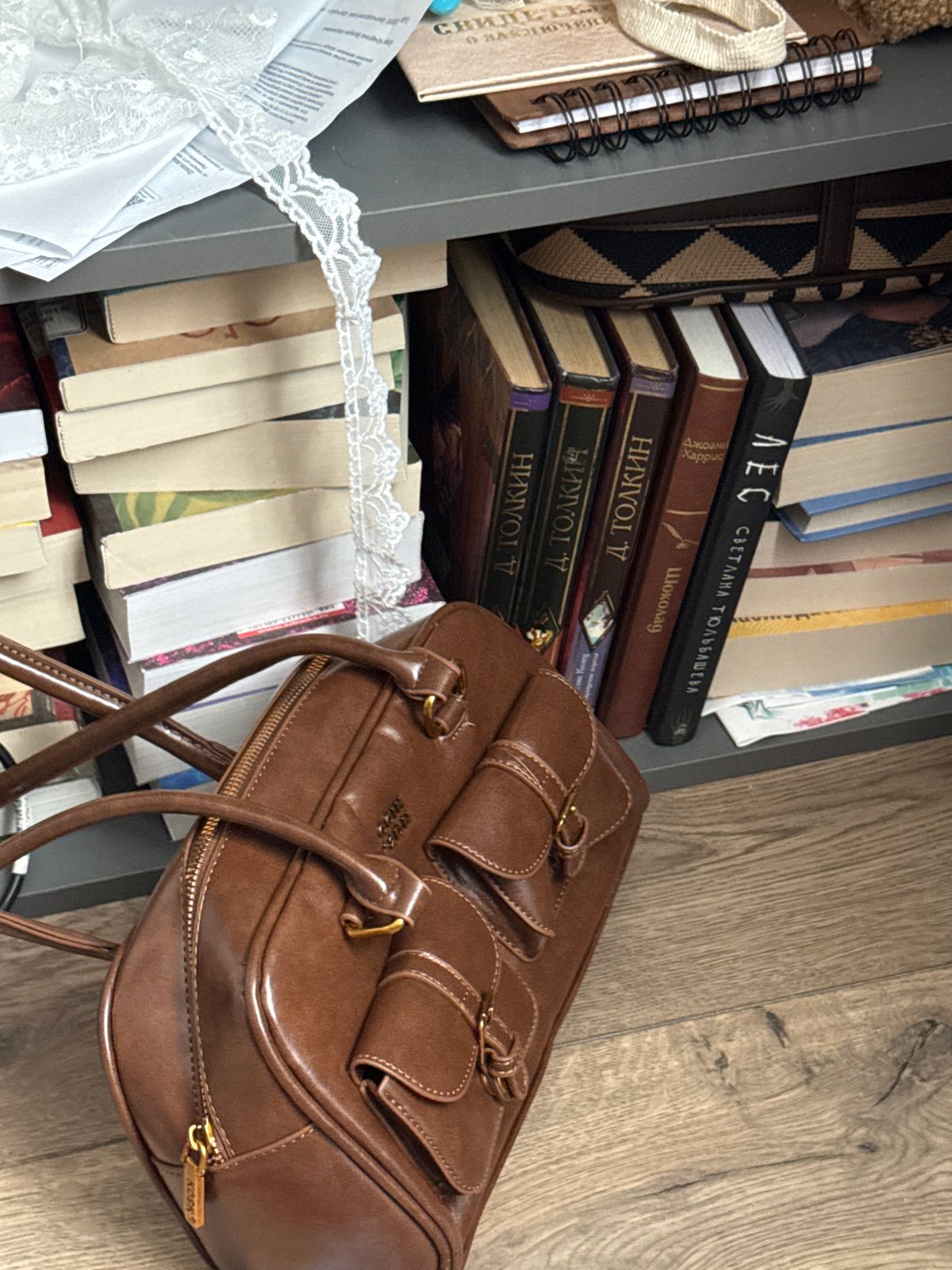 Woman takes selfie near handbags and books in Krasnodar home