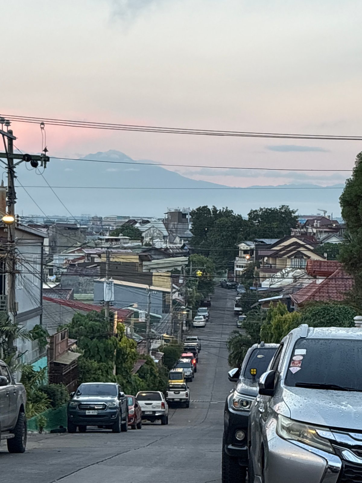 Davao City hillside streets at dusk, mountains on the horizon