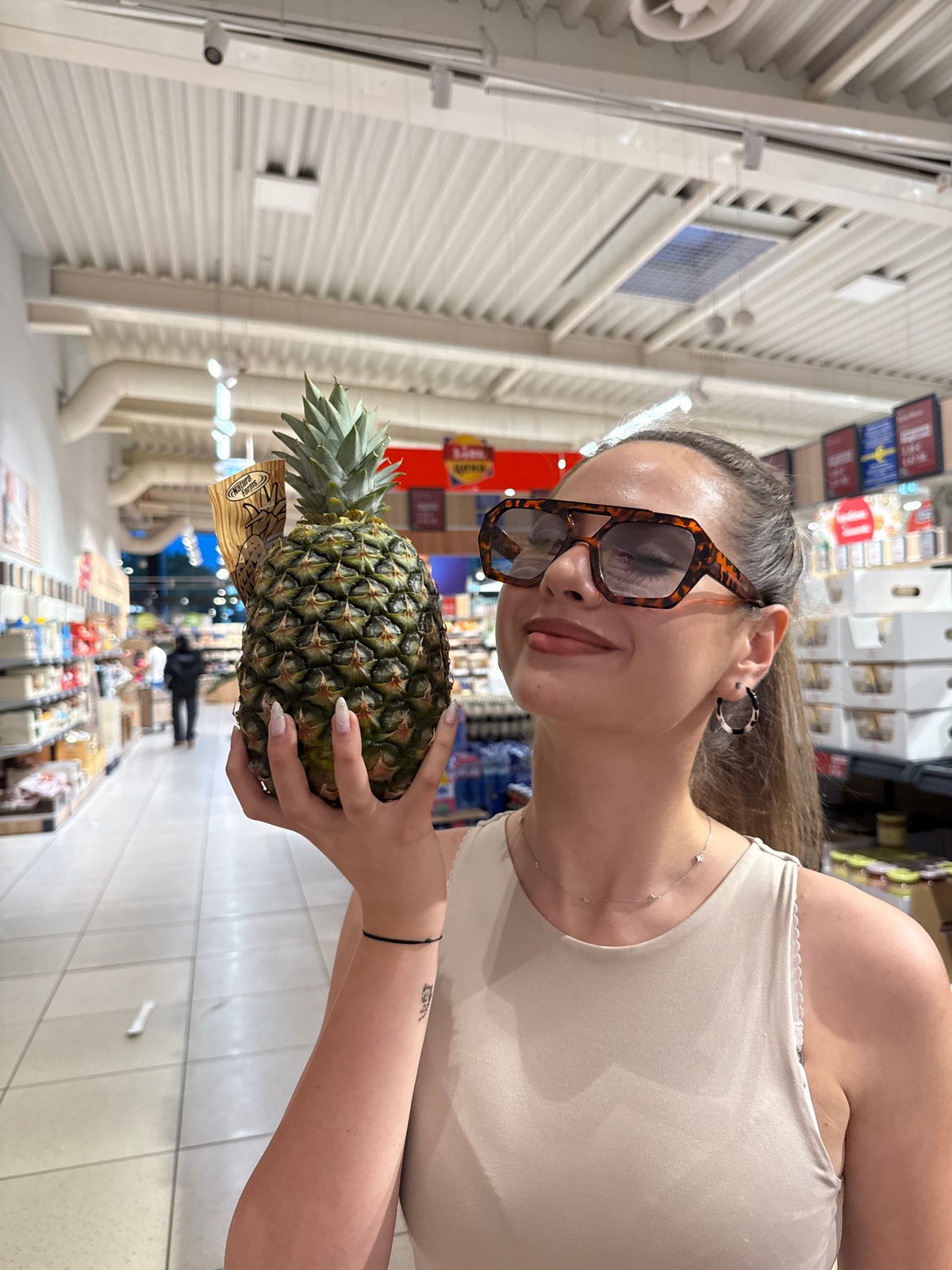 Woman shops with pineapple in Bulgarian supermarket