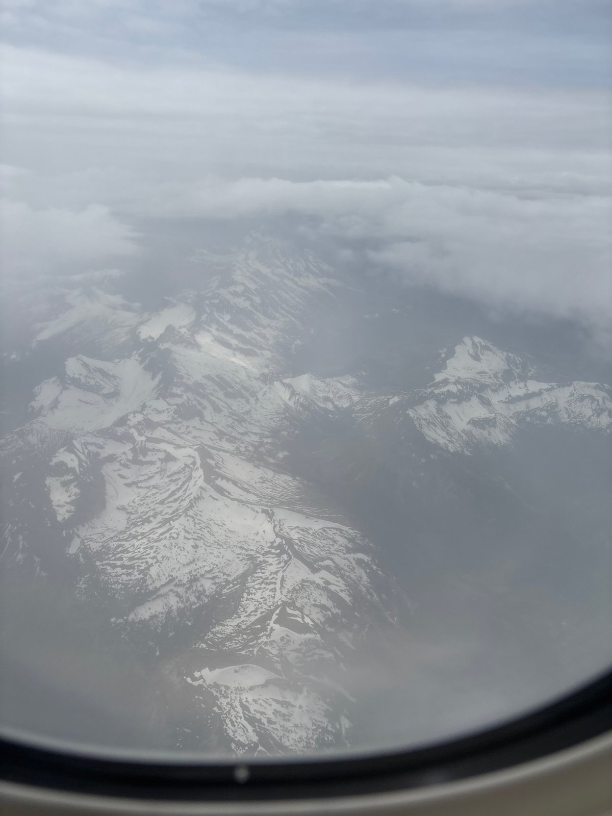 Aircraft passenger photographs cloudy mountain view over Quart, Italy