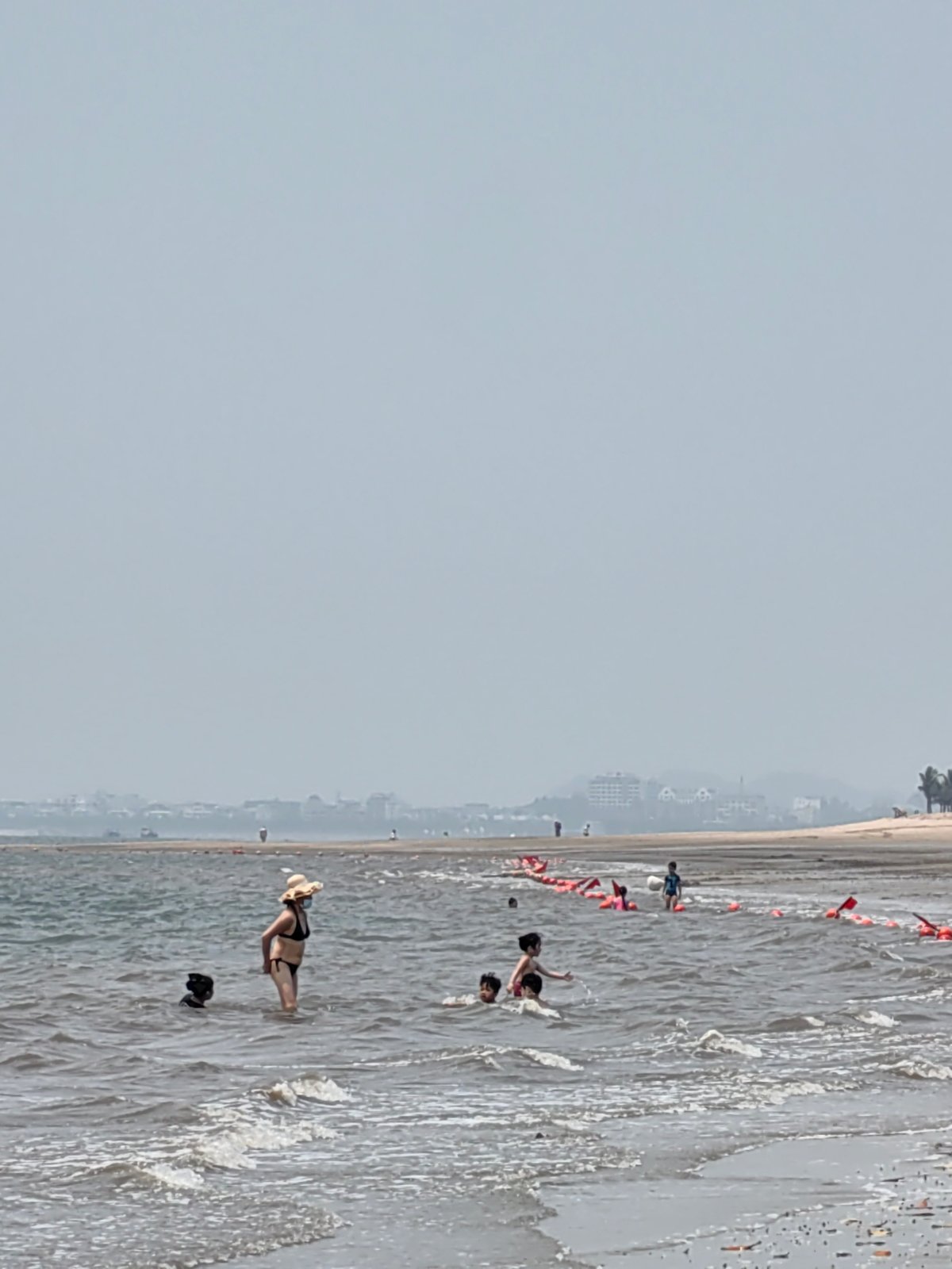 Man wades, gestures in early morning waters at Vietnam beach
