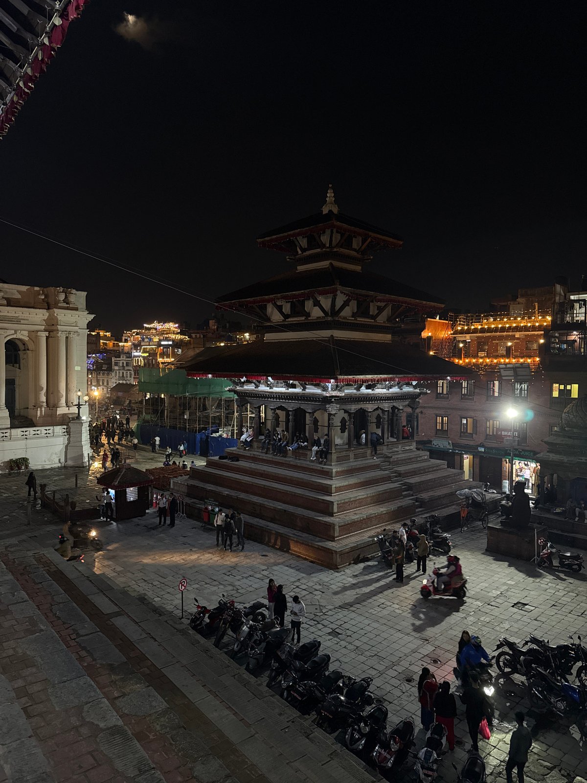 Nighttime activity documented around illuminated pagoda in Kathmandu square