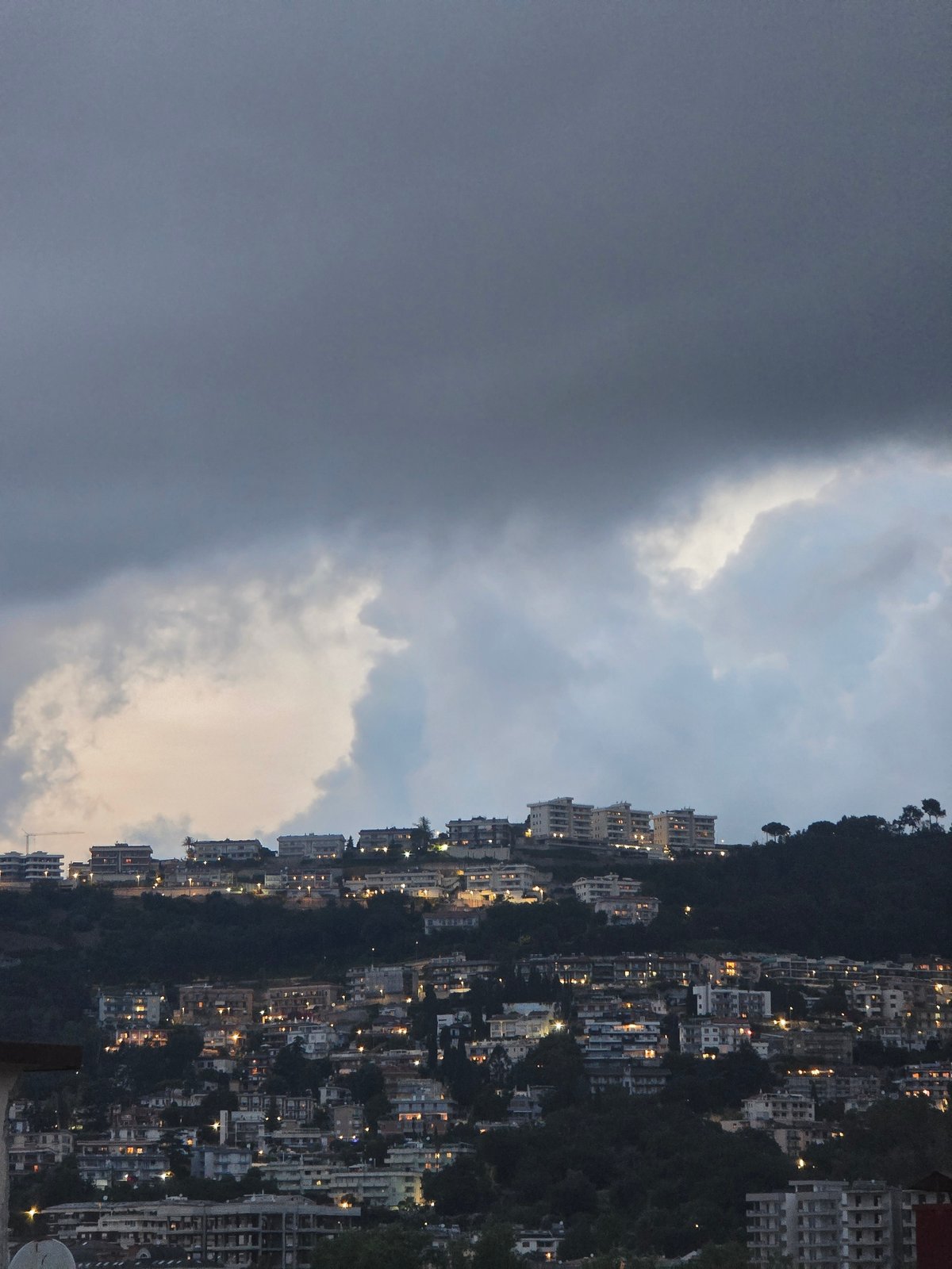 Evening scenes from Salerno: hillside cityscape and orange tabby cat
