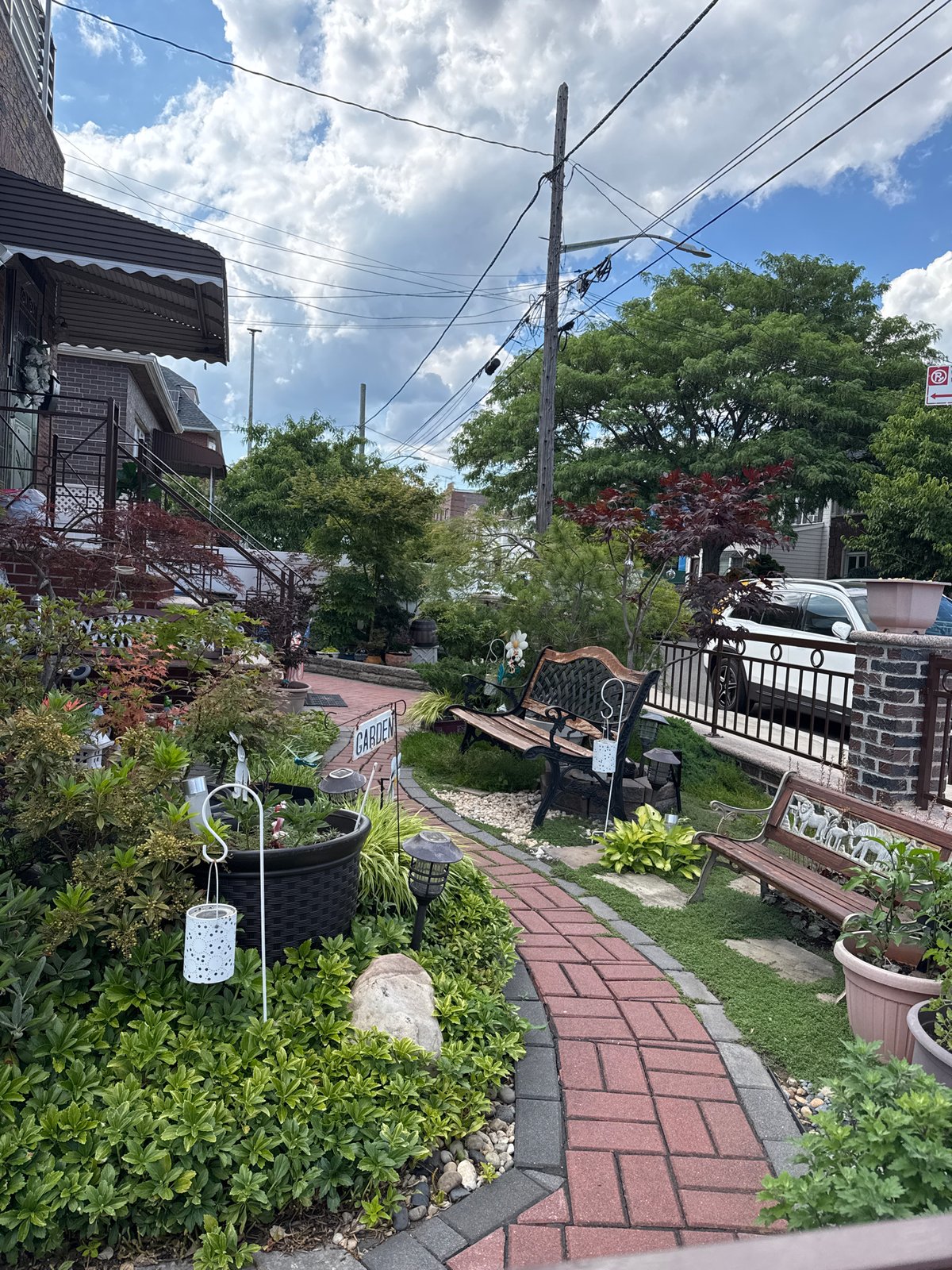 Ornament-packed Queens front garden in full summer bloom