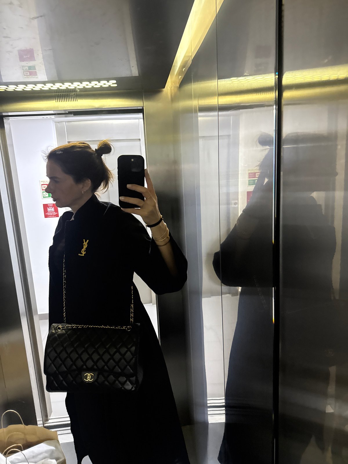 Woman takes elevator selfie in Lisbon wearing black outfit