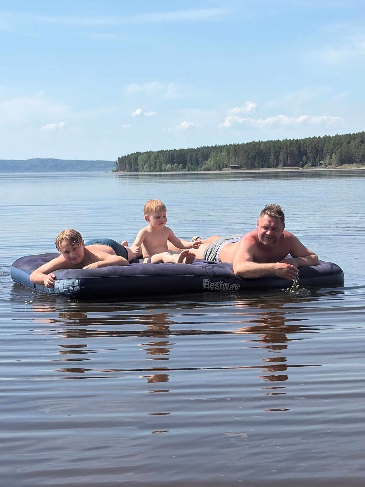 Family group rafting on lake near Vekoshinka, Russia