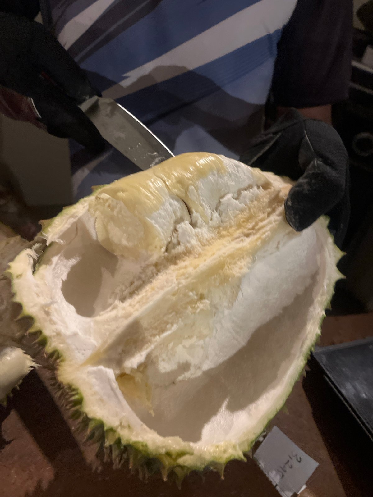 Durian vendor prepares spiky fruit at Kuta Selatan stall