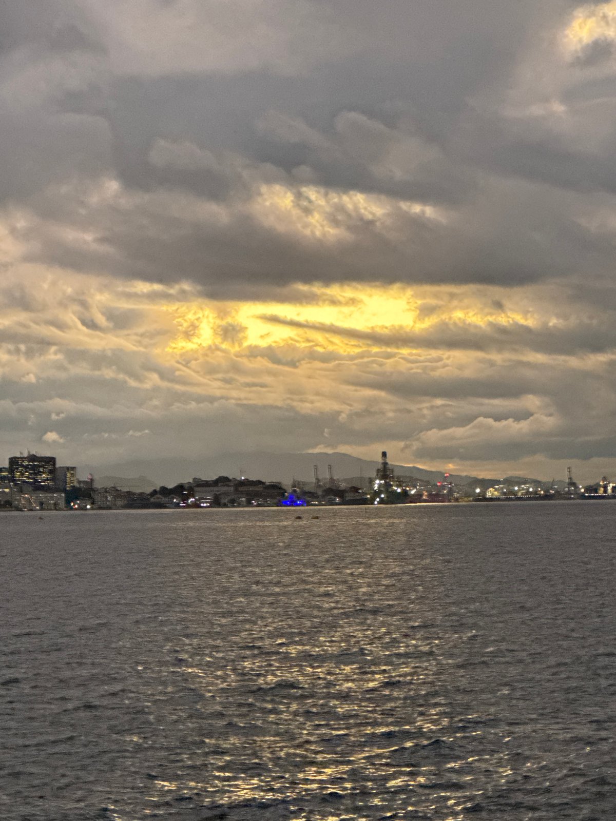Niterói skyline at dusk, calm water and breaking light