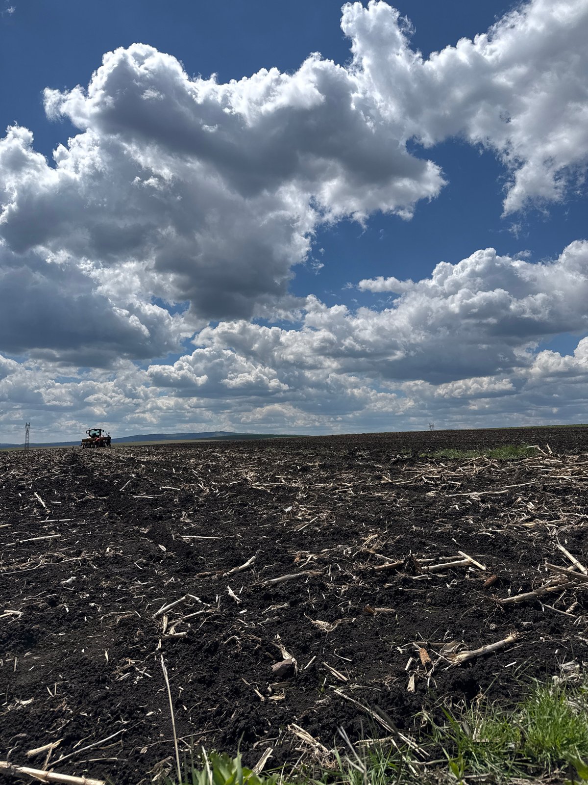 Crane truck lifts white bag in Bulgarian field