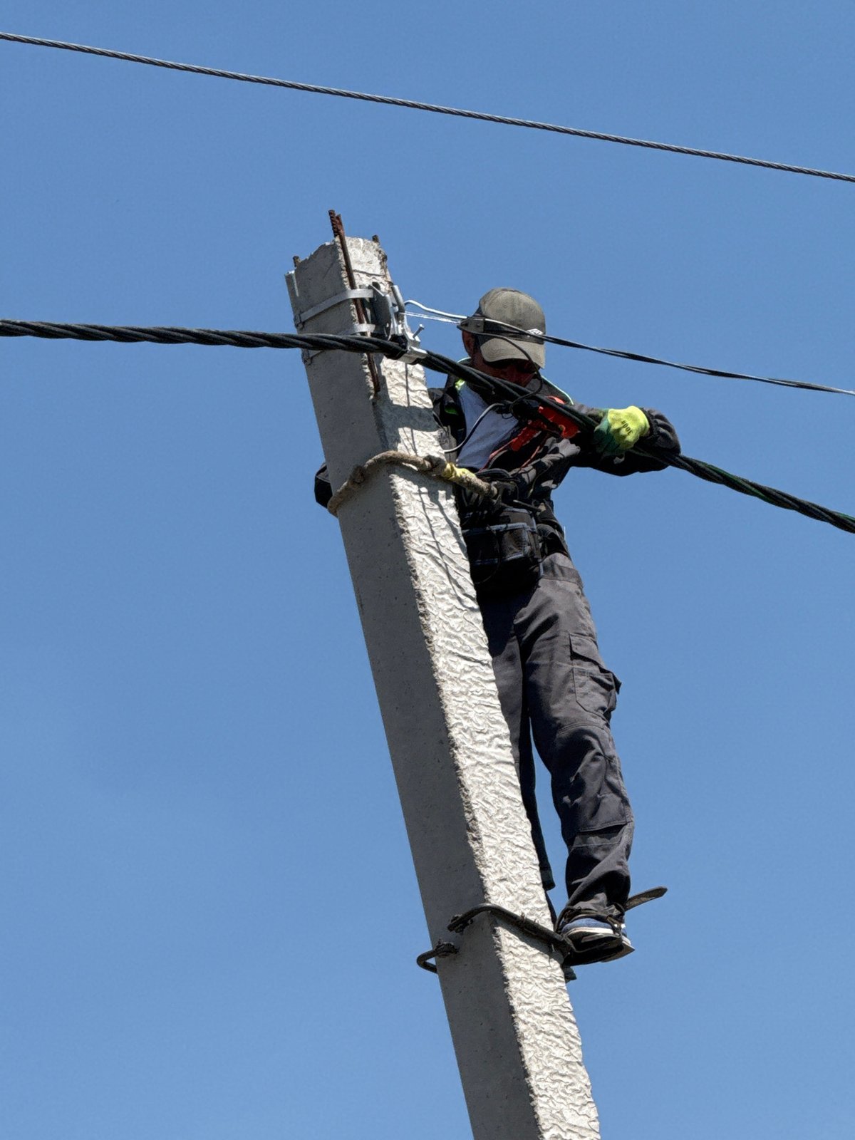 Construction worker performs high-altitude beam work with safety equipment