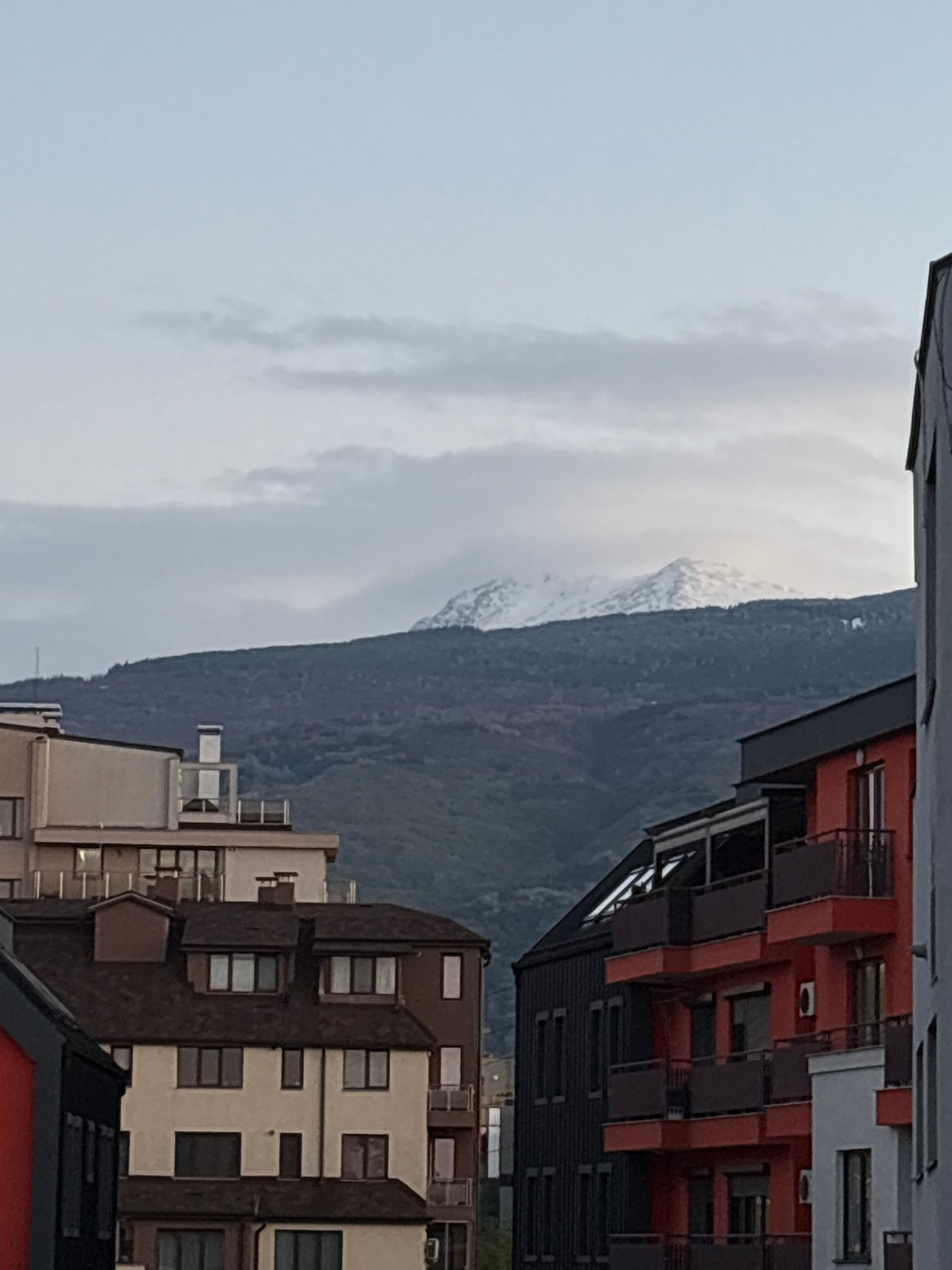 Snow-capped mountains viewed from Sofia under overcast afternoon skies