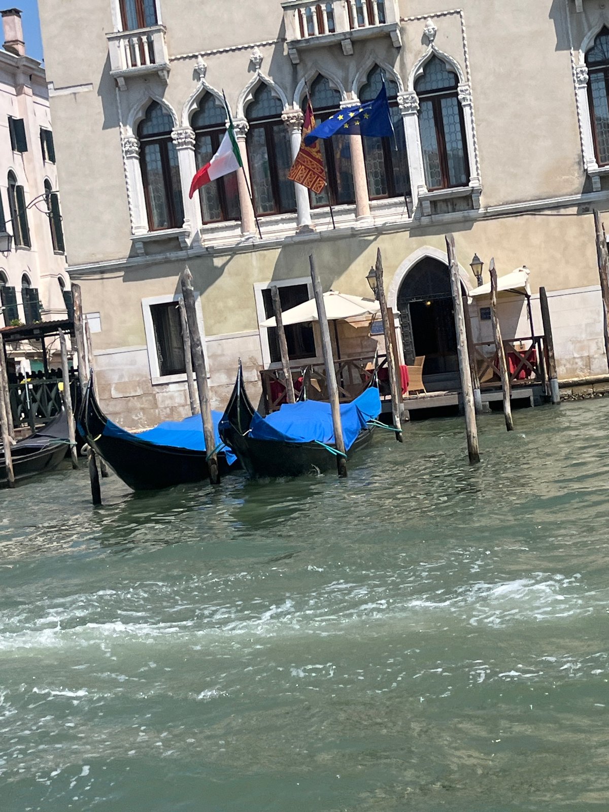 Boats and gondolas along Venice's canals on a clear morning