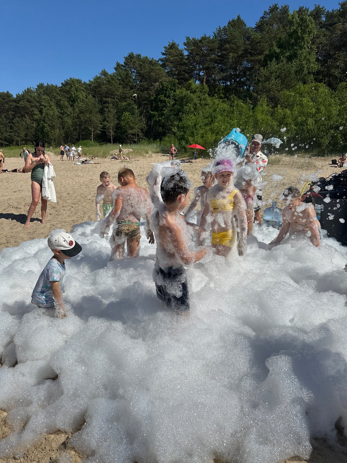 Foam party on Jūrmala's sandy beach on a sunny day