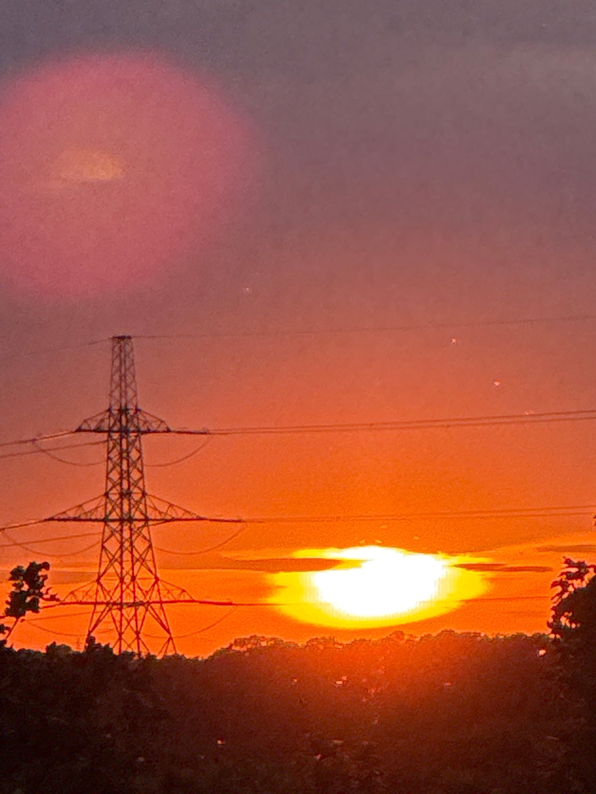 Pylons and power lines silhouetted against a Grays sunset