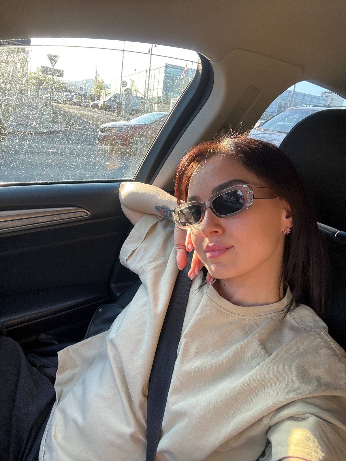 Woman photographed in multiple poses inside car in Tbilisi