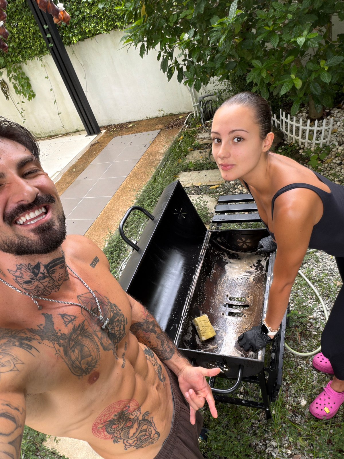 Woman cleans backyard grill in Chalong, Thailand