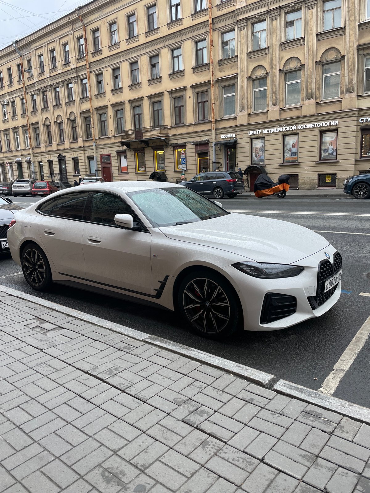 White BMW parked on cobblestone street in Saint Petersburg