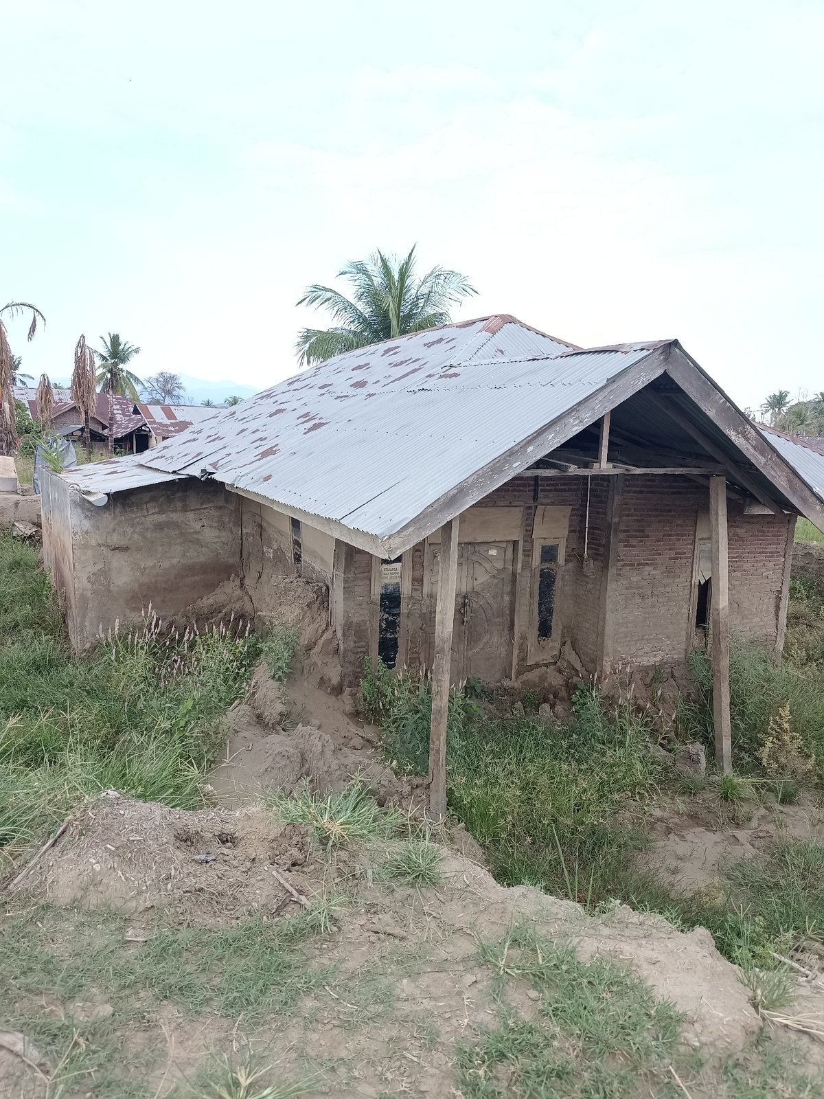 Damaged village structures and disturbed land in rural Aceh