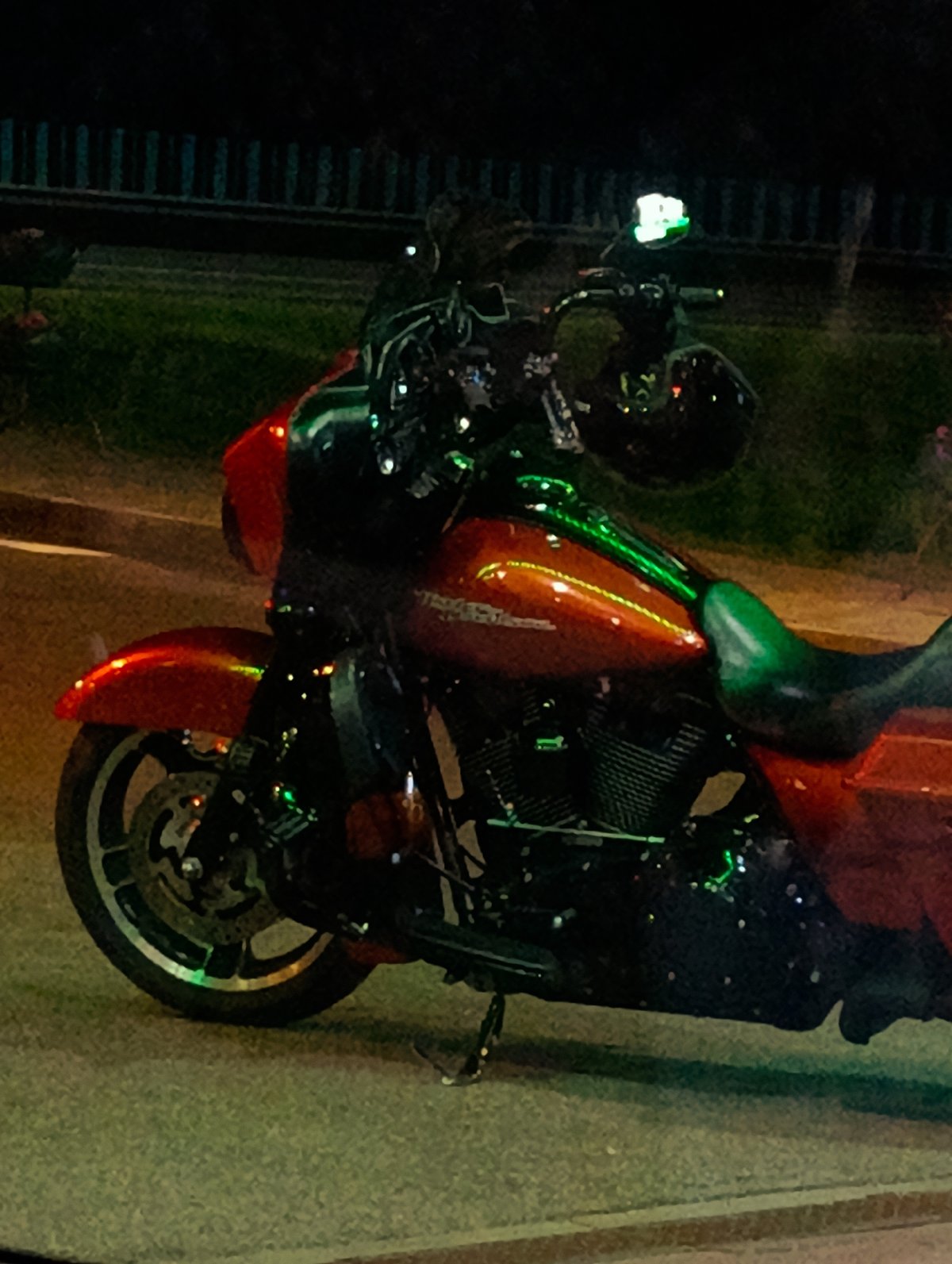 Red motorcycle parked under city lights on a quiet night
