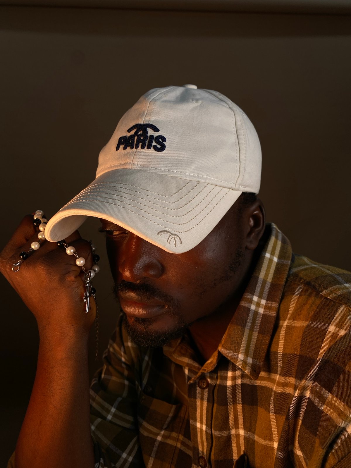 Studio portrait session in Gura Top, Nigeria, with rosary and Paris cap