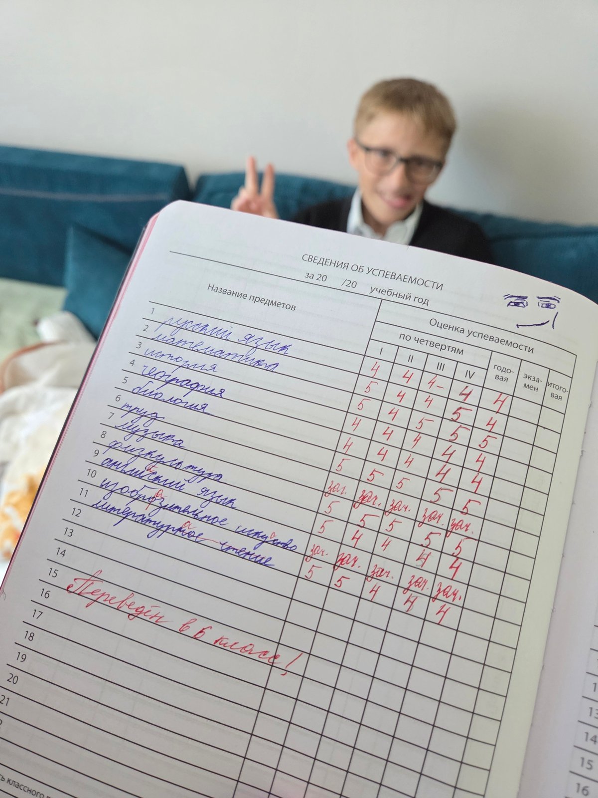 Student displays school records while making peace sign in Birobidzhan