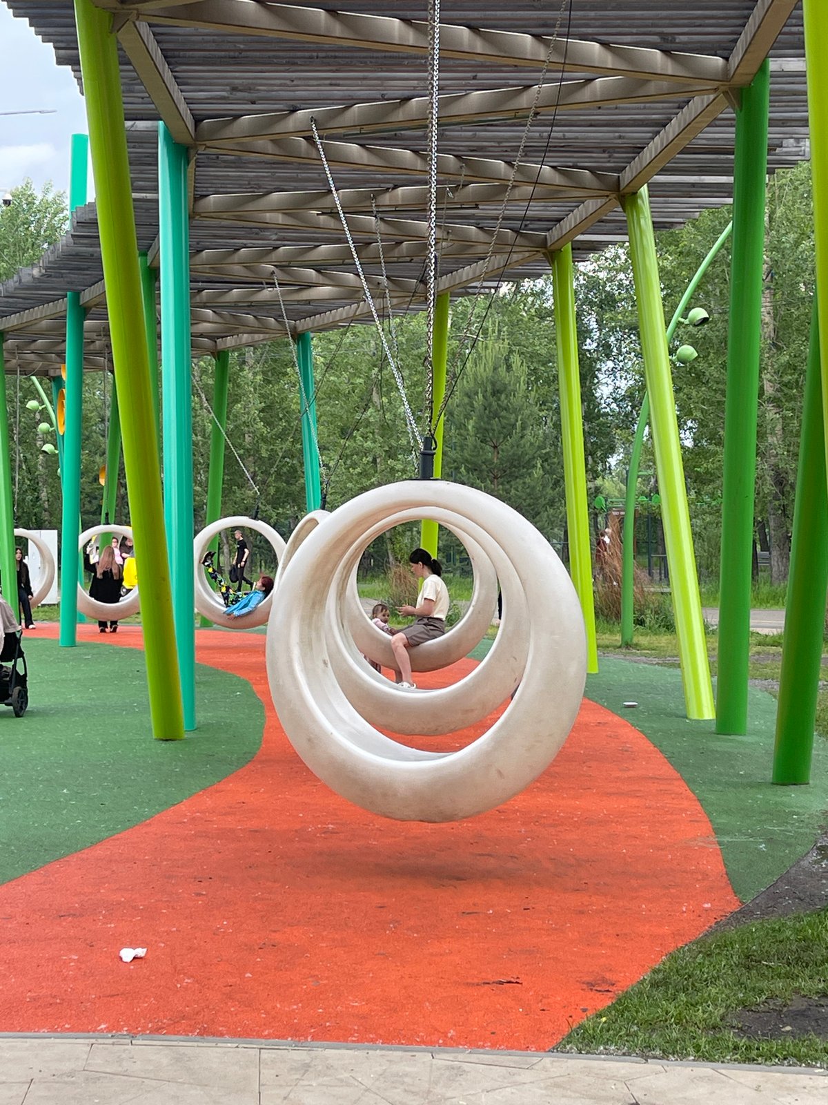 A busy Krasnoyarsk park with games, playgrounds, and art installations