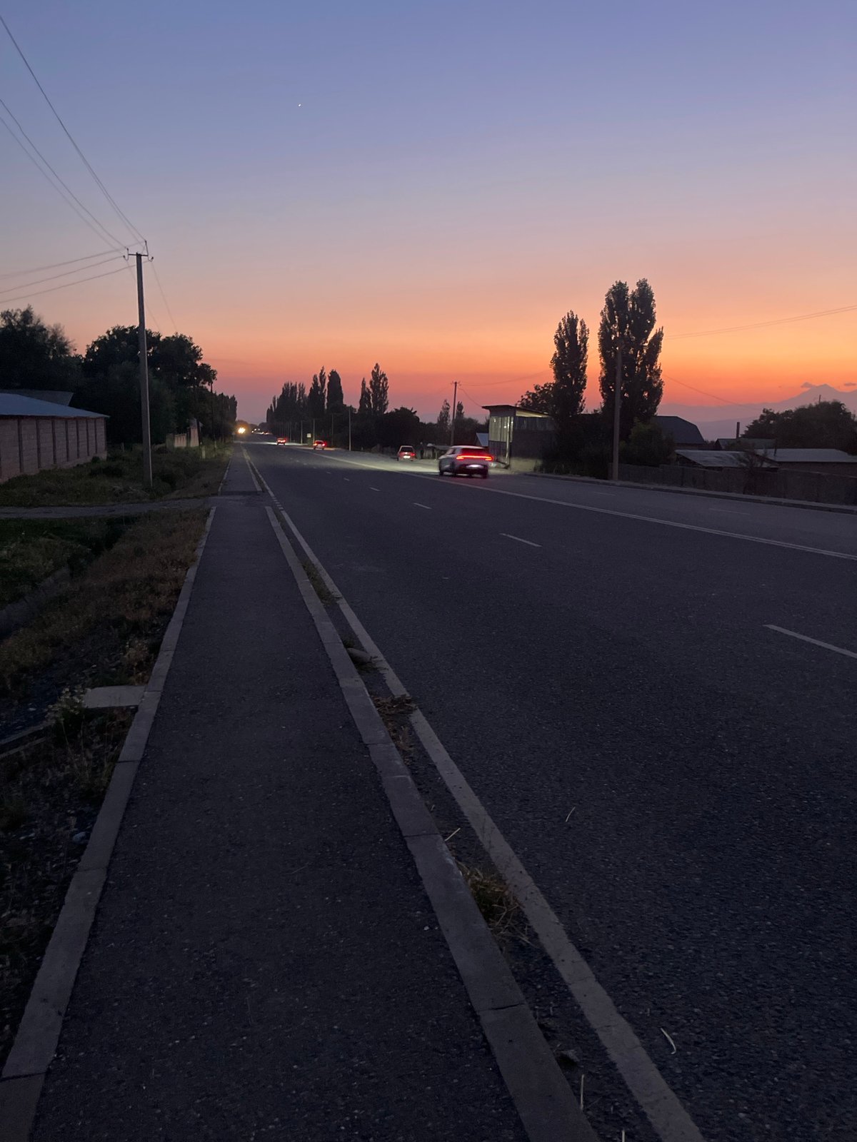 Dusk settles over a road in Taran-Bazar, Kyrgyzstan