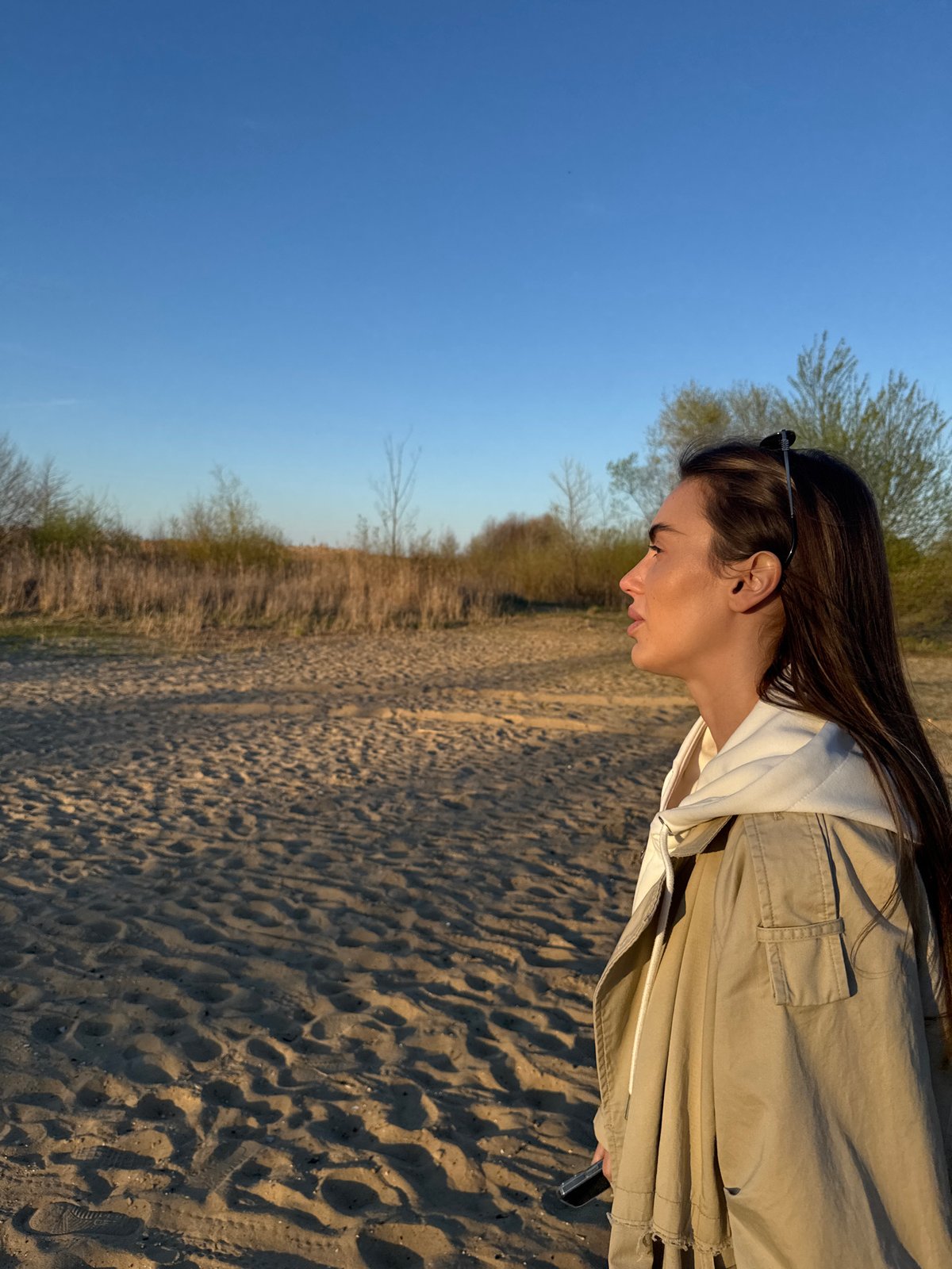 Woman watches sunset at lake in Arciechów, Poland