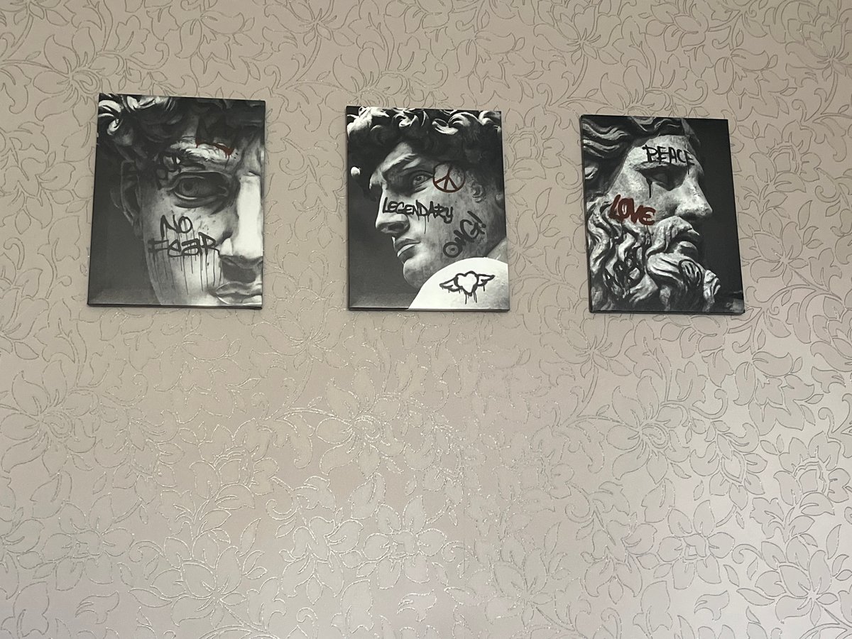 Interior artwork display documented in floral-wallpapered room