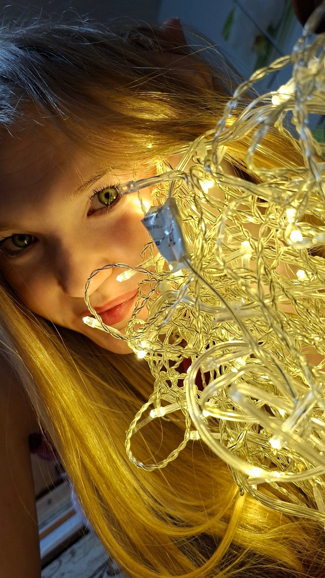 Young woman poses with fairy lights in Russian photoshoot