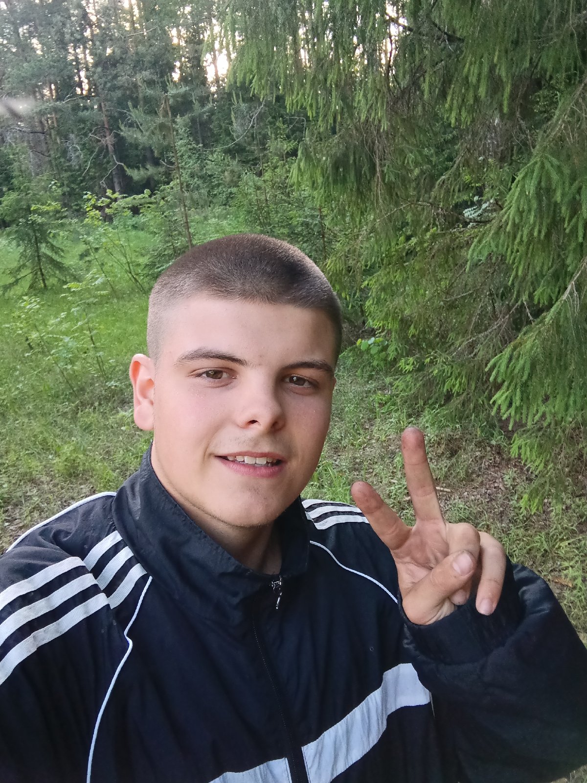 Young man takes selfie portrait in wooded setting