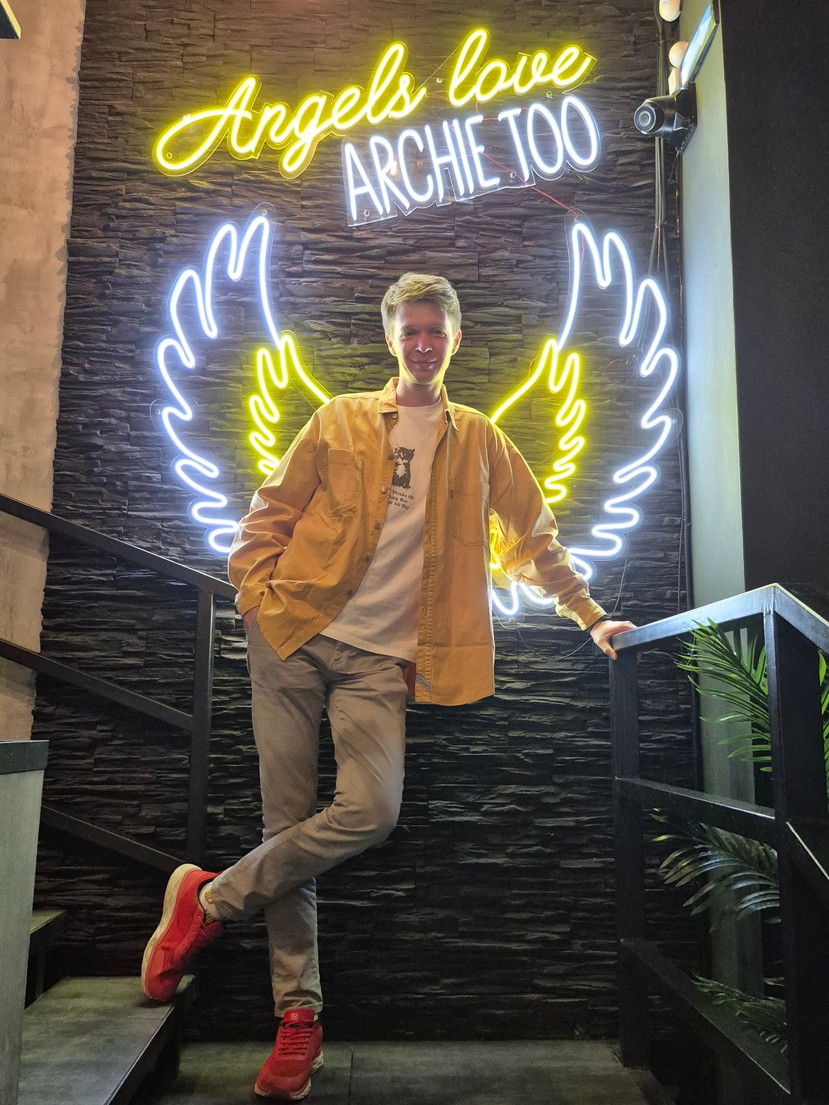 Social gathering at neon-lit venue in Izhevsk features angel-themed decor