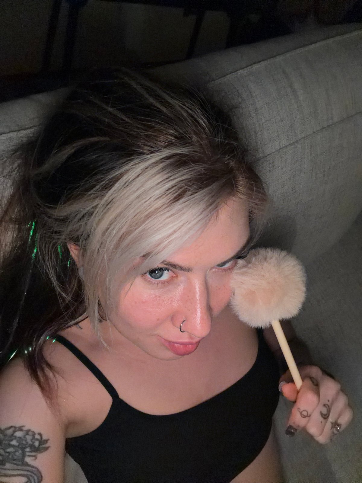 Woman applies makeup while gaming on couch in Budva