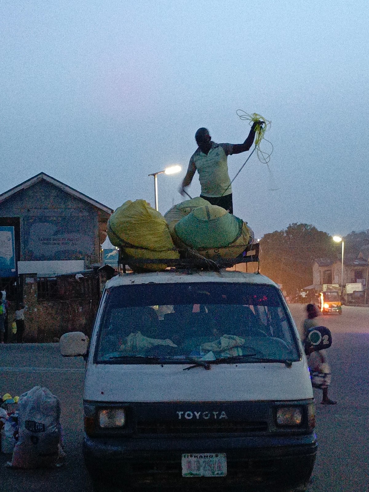 Man secures cargo atop loaded Toyota van