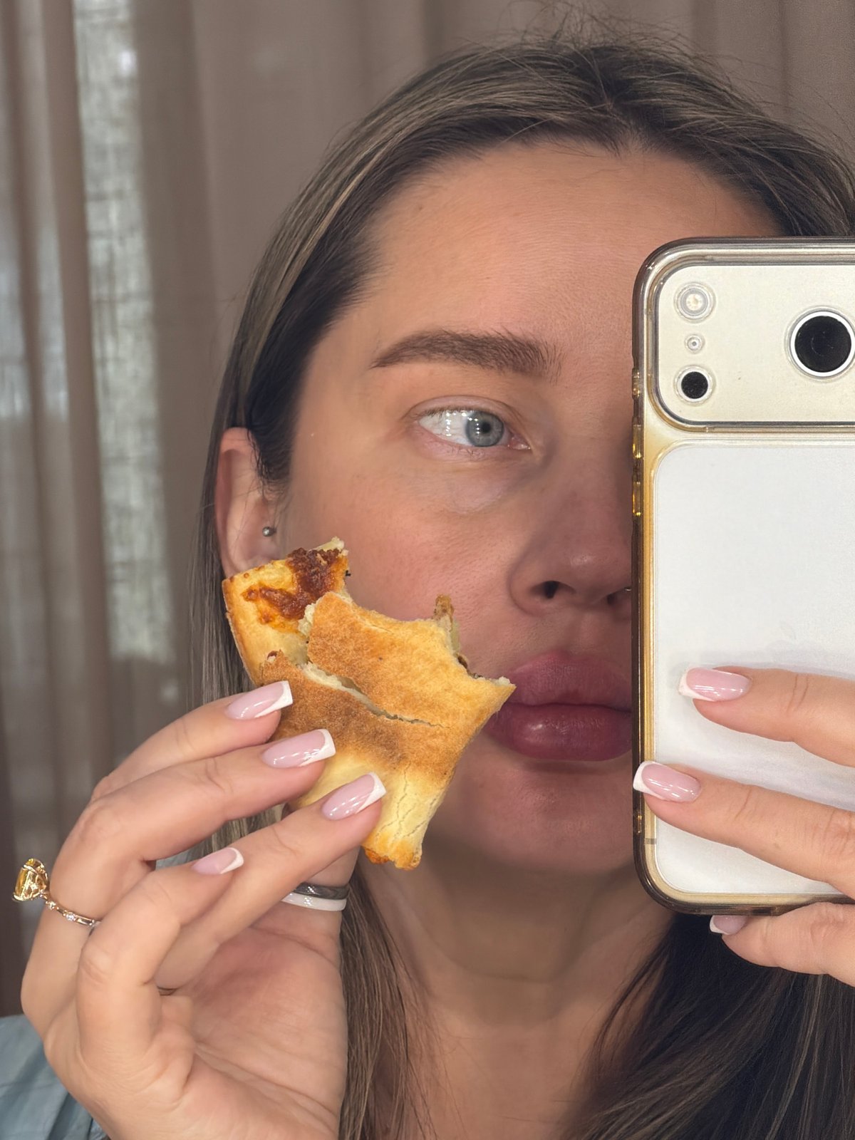 Woman eating pizza while using phone in Moscow