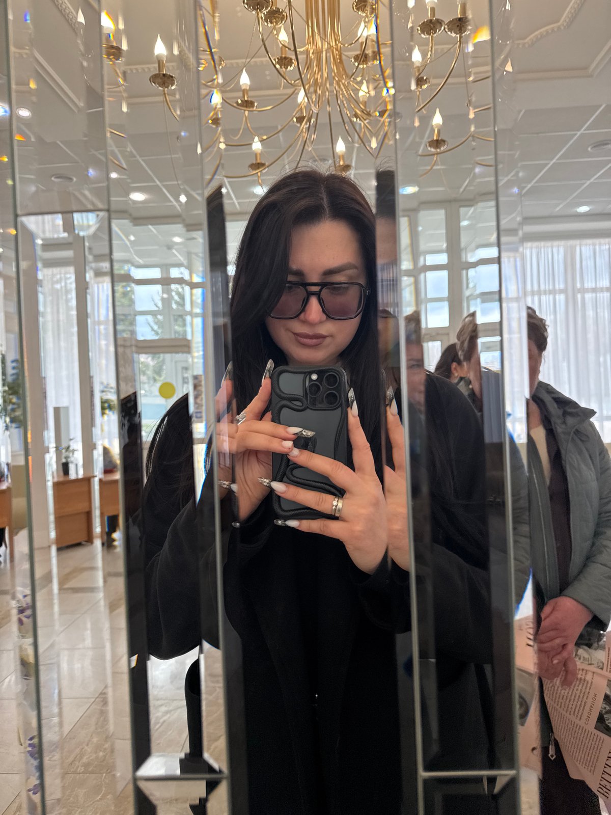 Selfie captured in ornate mirror within elegant lobby space