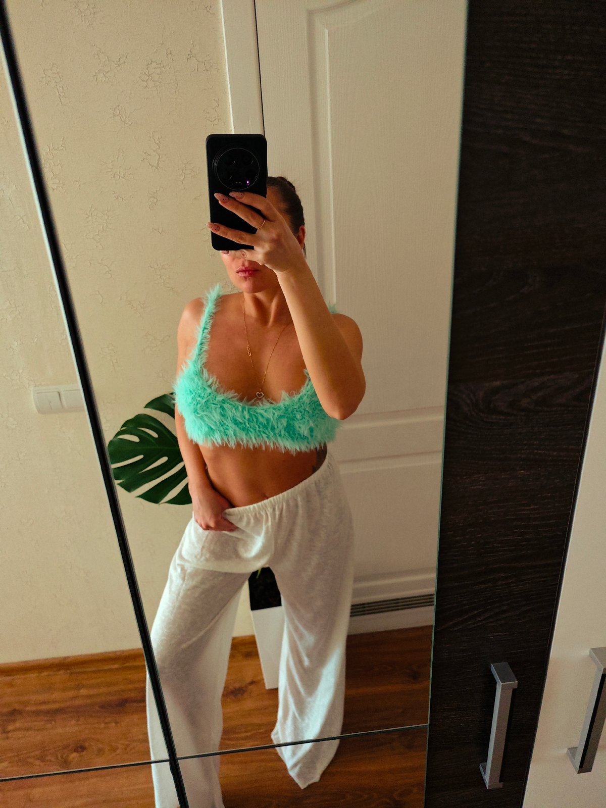 Woman takes mirror selfie in green top in Chaikovsky