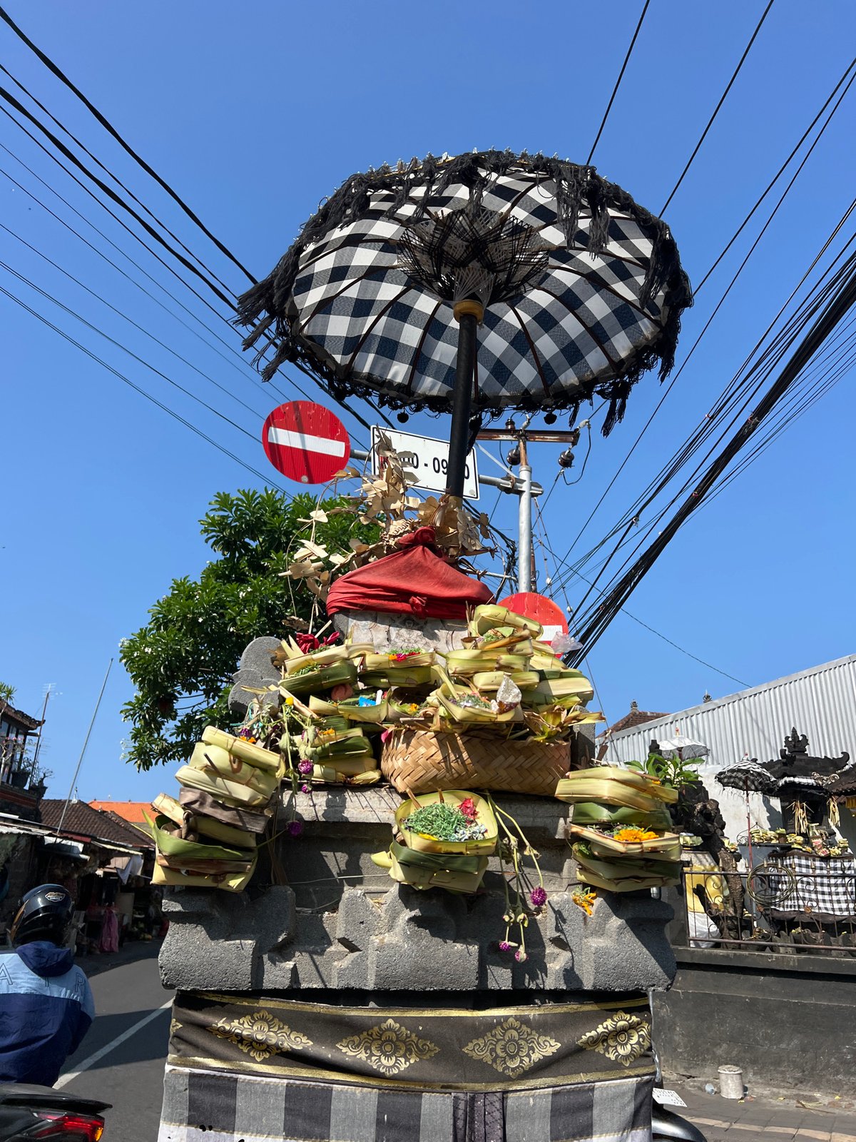Morning street life and traditional shrine documented in Denpasar