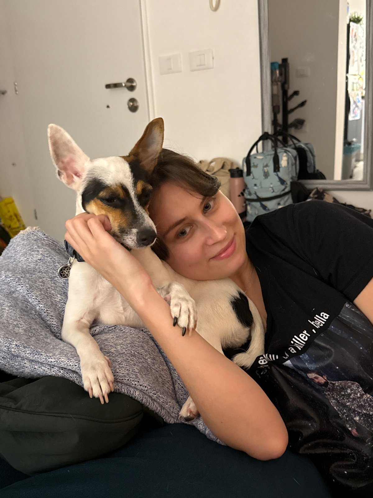 Woman relaxes with pet dog on couch in Tel Aviv