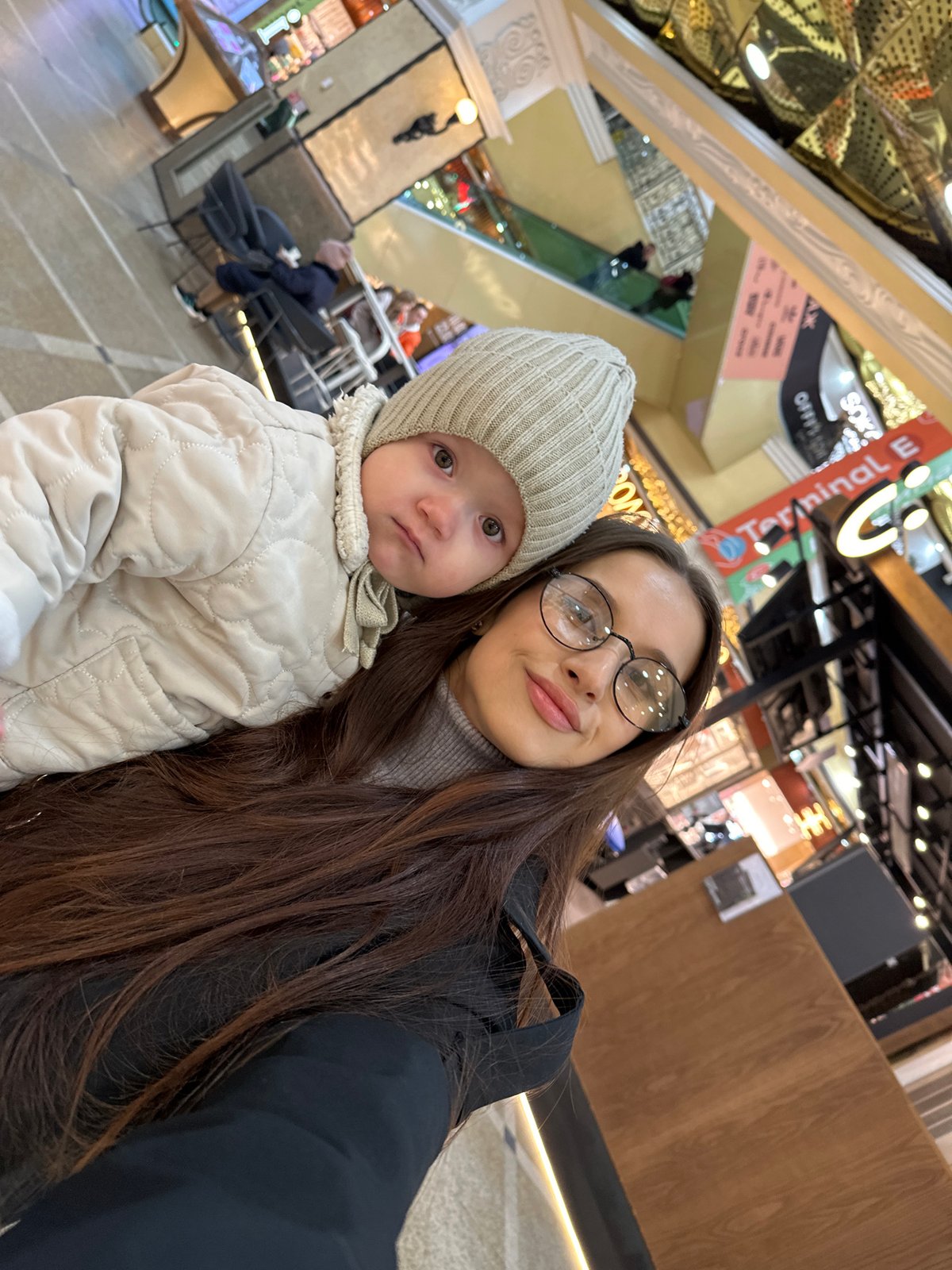 Woman and toddler shop, take selfies at Yekaterinburg mall