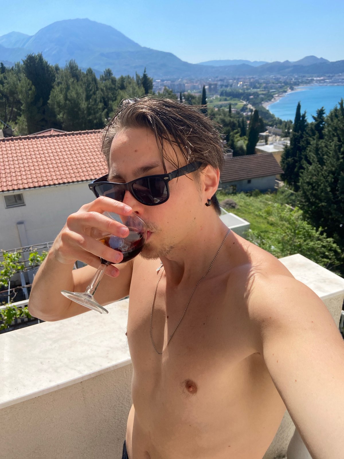 Man enjoys morning drink on coastal balcony in Montenegro