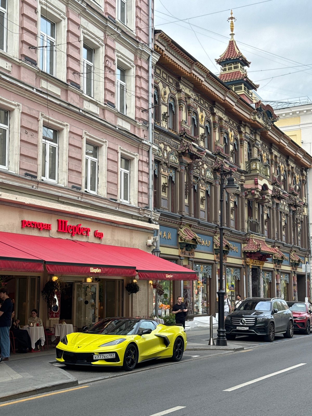 Yellow Corvette parked outside Moscow restaurant near East Asian-style building