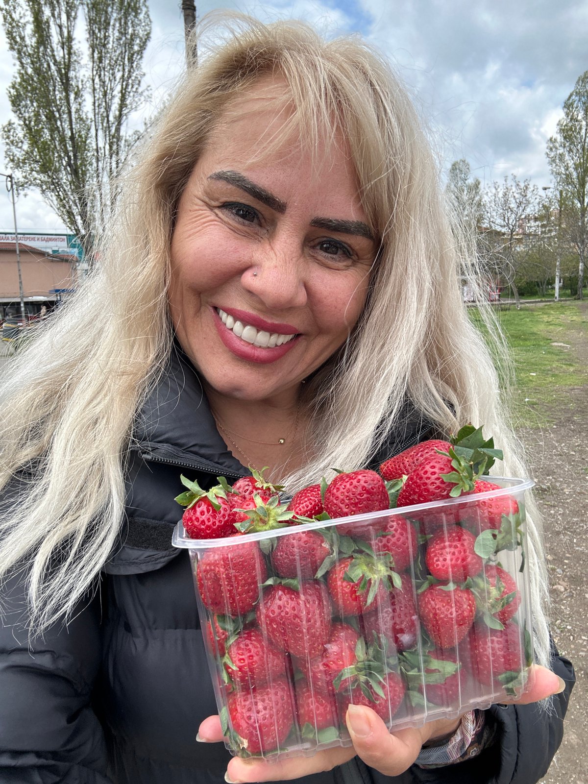 Woman holds fresh strawberries outdoors in Sofia