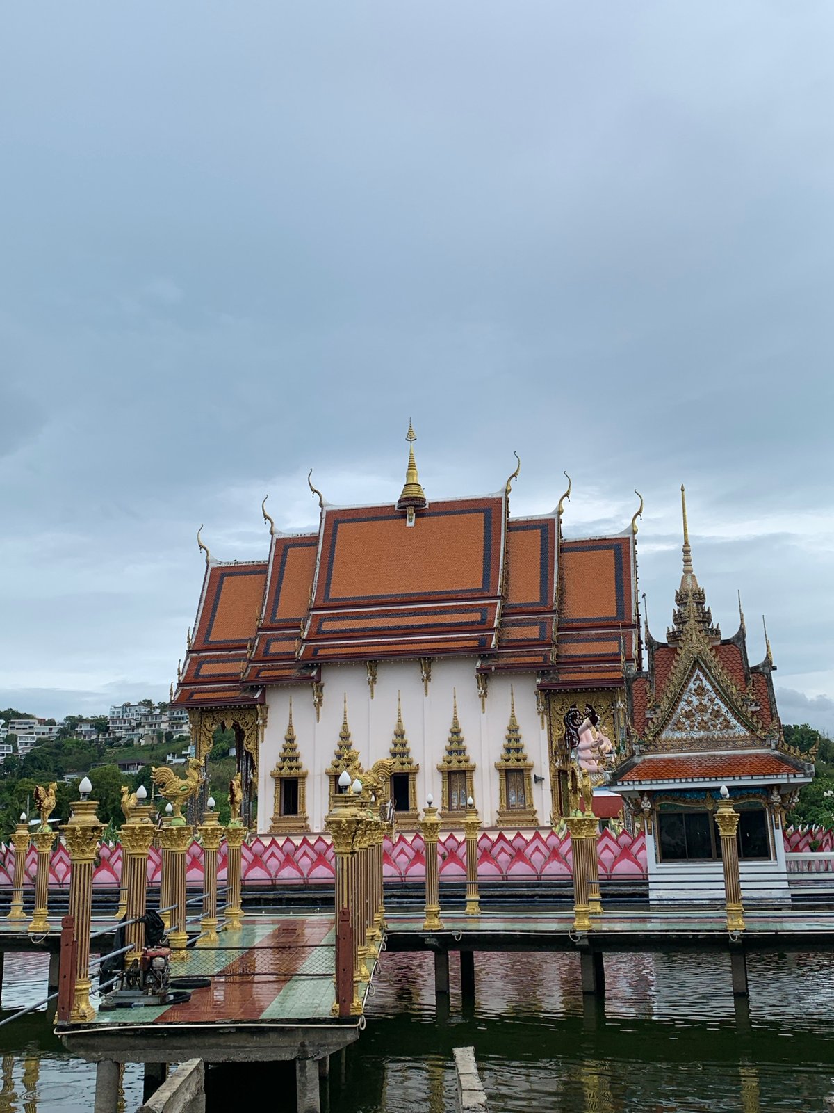 Tourist captures Thai temple complex with Buddhist statues, architecture