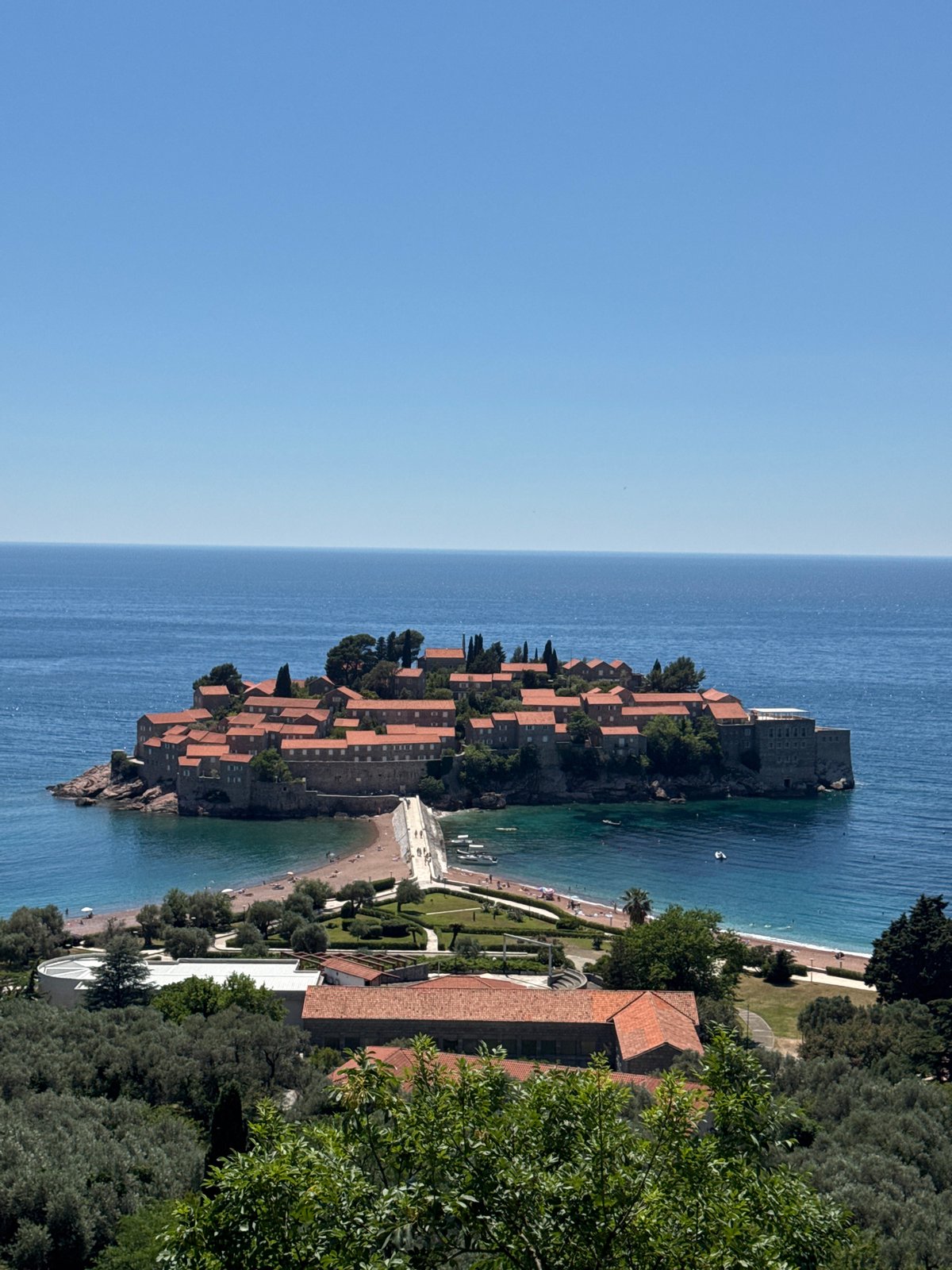 Tourist photographs iconic Sveti Stefan islet resort in Montenegro
