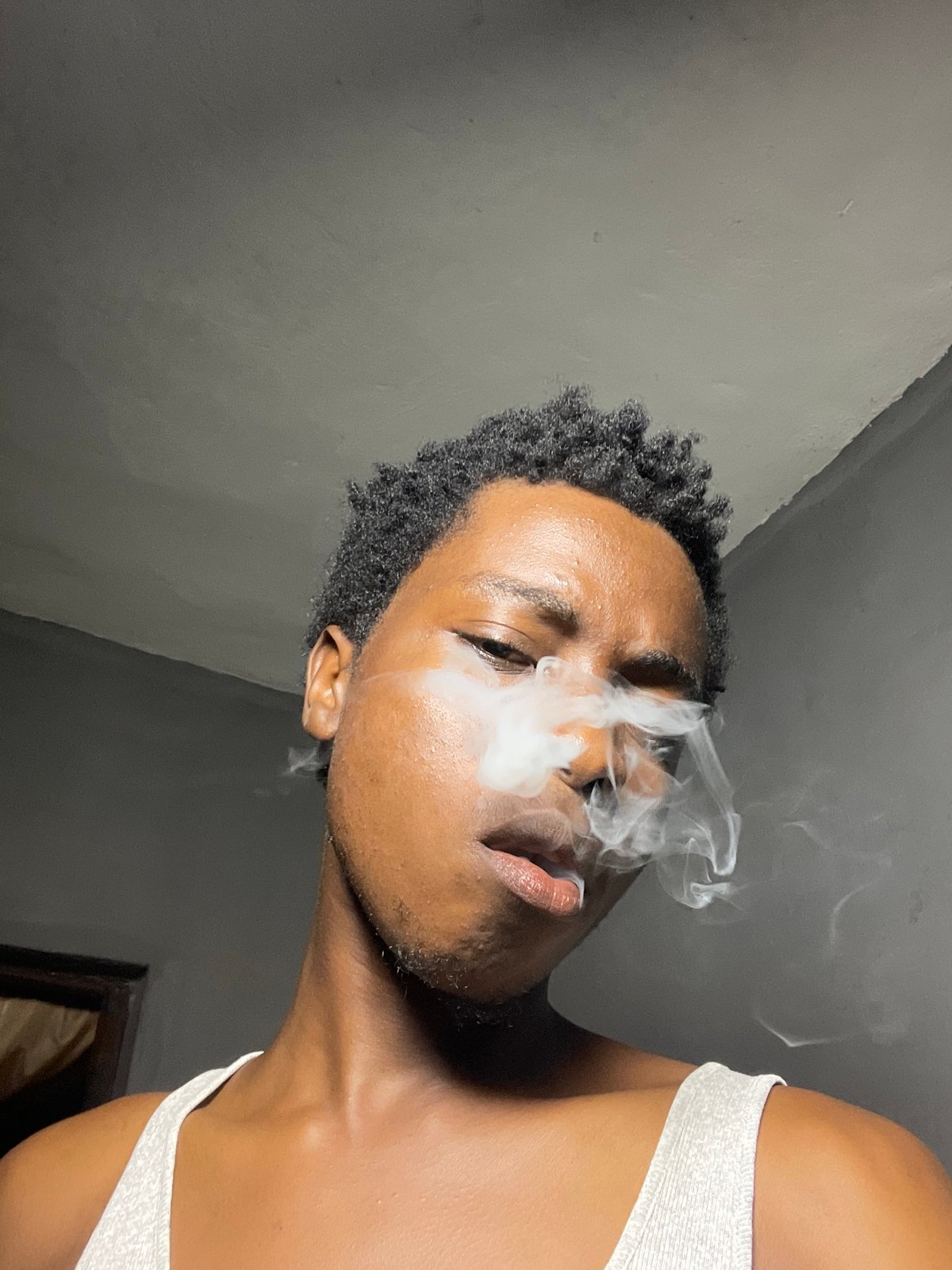 Face paint and smoke in a colorfully lit Nkpor interior
