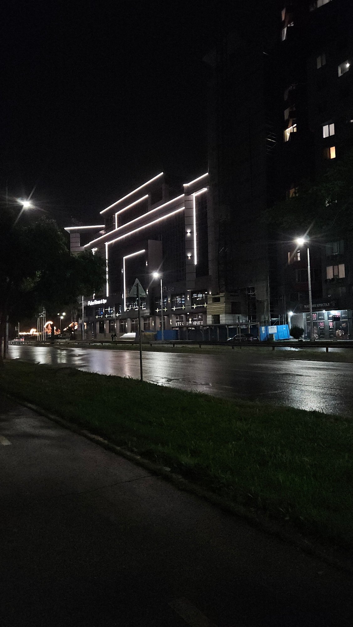 Rainy night scene captured on Plovdiv street with reflective pavement