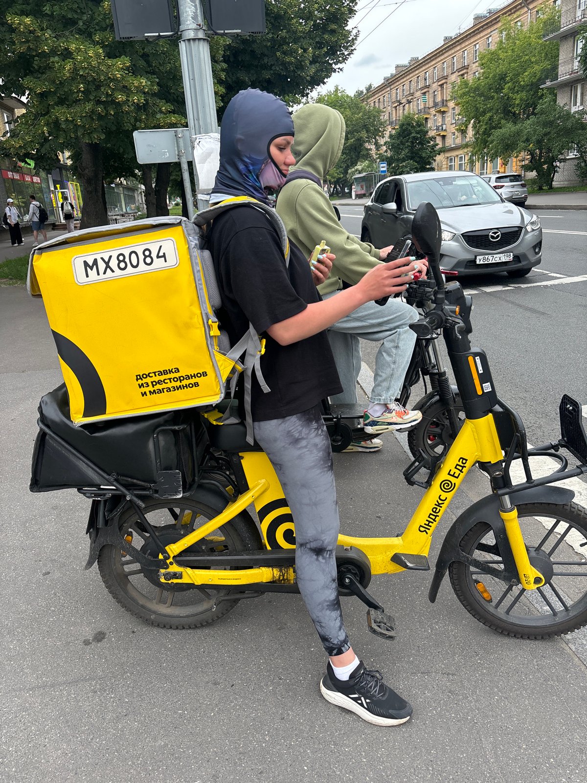 Selfies and a yellow delivery scooter in an outdoor setting