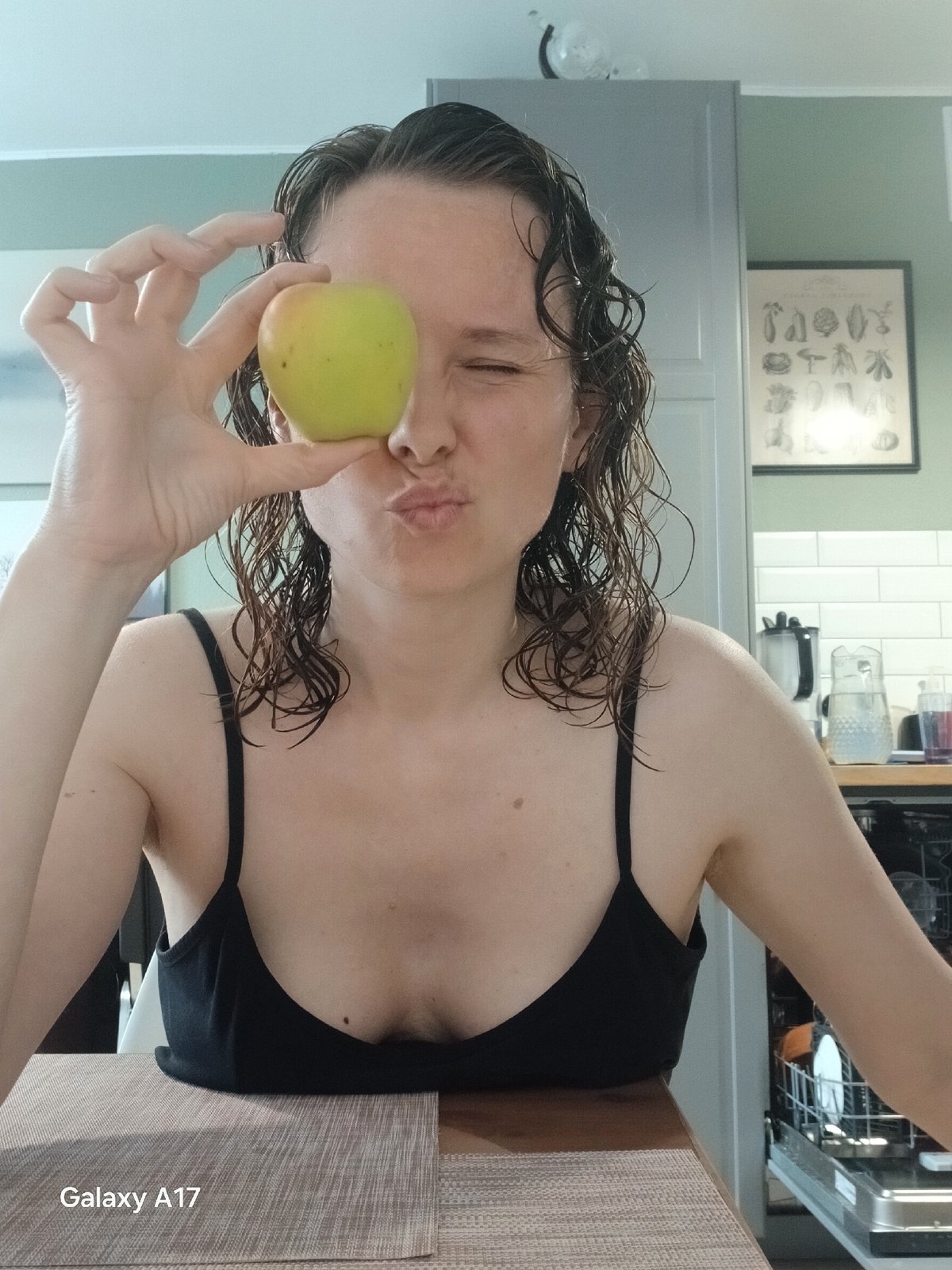 Woman poses with green apple in Yekaterinburg kitchen