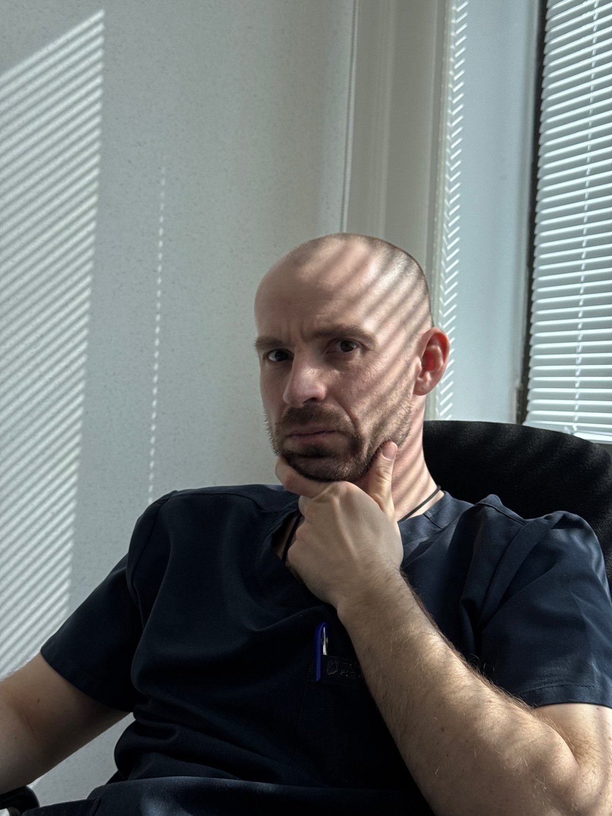 Man poses for casual portraits near window in Russia